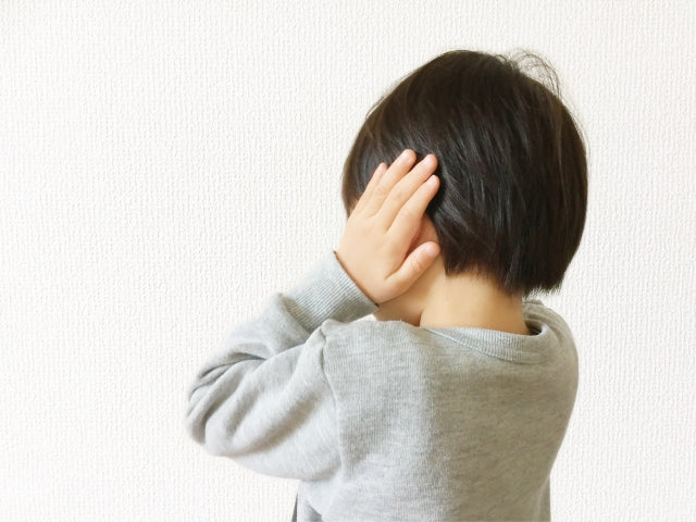 手で耳をふさぐ子ども