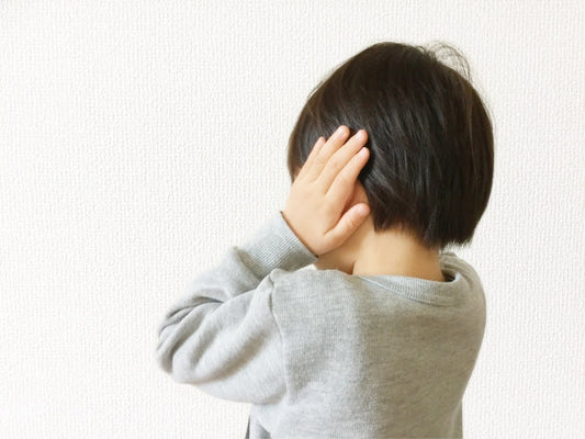 手で耳をふさぐ子ども