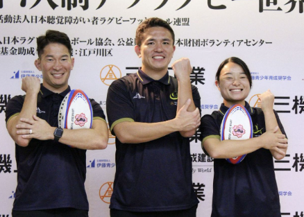 ラグビーを表す手話で写真撮影に応じる、デフラグビー男子日本代表の（左から）大塚貴之と岸野楓＝東京都新宿区