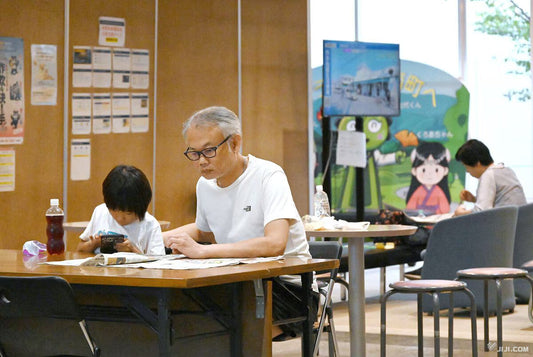 長男（左）らと指定避難所で生活を続ける聴覚障害者の脇山敬右さん＝１９日、熊本市南区