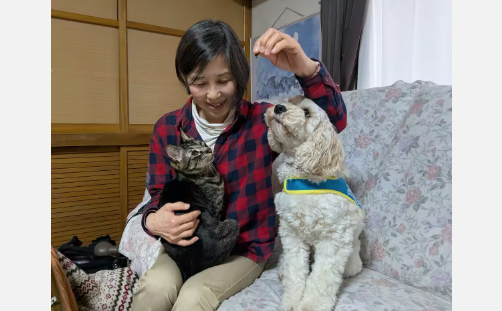 鶴村さんの下でともに過ごすグレースと飼いネコの梅次郎＝4月4日、広島県呉市（矢田幸己撮影）