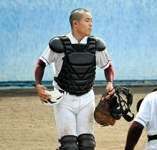 難聴のため、補聴器をつけて守備に向かう玉名の鶴山櫂士捕手=2026年7月11日、熊本県八代市の県営八代野球場、伊藤隆太郎撮影