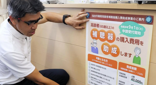 補聴器を取り扱う店に啓発ポスターを張るスタッフ＝仙台市青葉区二日町の仙台リオン補聴器センター仙台店