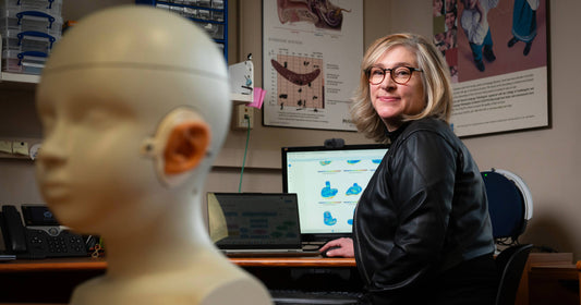 子どものダミーヘッドを見つめる女性