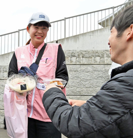 メダルを獲得した大阪の選手（右）と、笑顔で触れ合う向谷地さん＝24日午後、青森市のカクヒログループアスレチックスタジアム